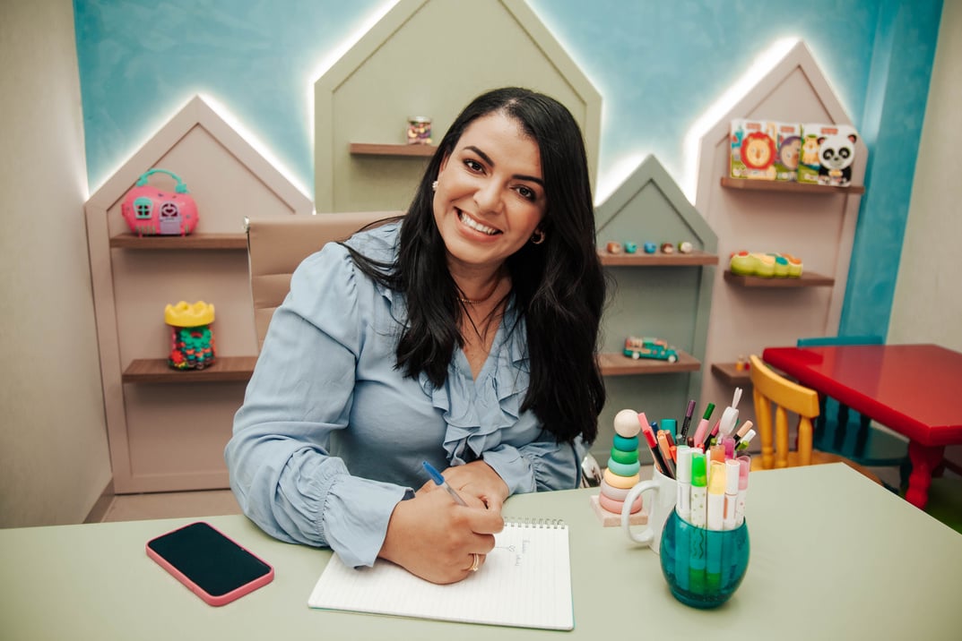 Psicólogas realiza anotações em uma sala colorida e divertida